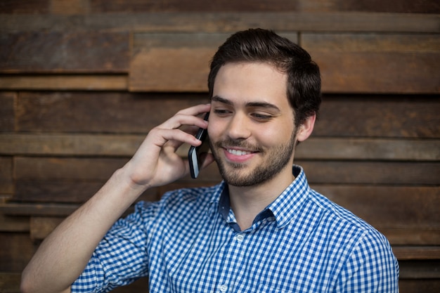 Uomo d'affari sorridente che parla sul telefono cellulare