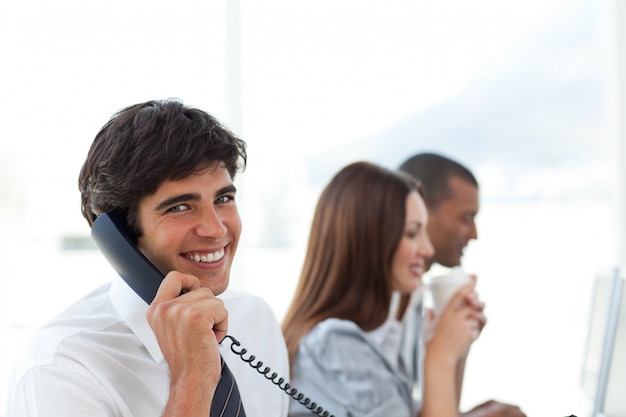 Uomo d&#39;affari sorridente che parla sul telefono