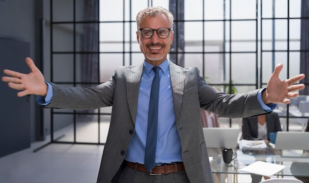 Uomo d'affari sorridente che ti saluta nel suo ufficio