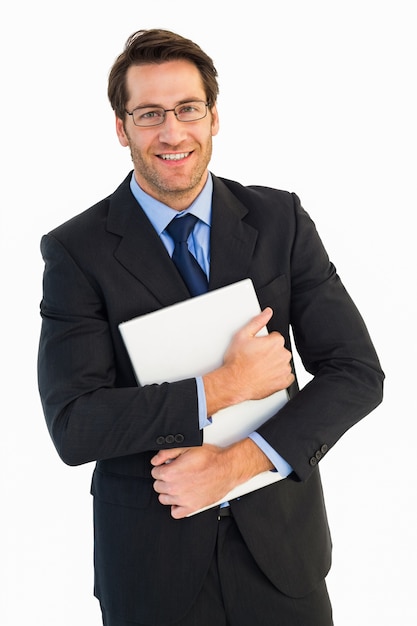 Uomo d&#39;affari sorridente che tiene il suo computer portatile che esamina macchina fotografica