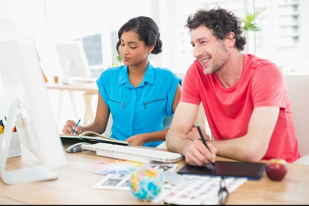 Uomo d&#39;affari sorridente che utilizza computer portatile e digitalizzatore