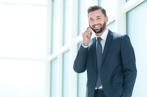 Uomo d'affari sorridente da vicino che parla al telefono