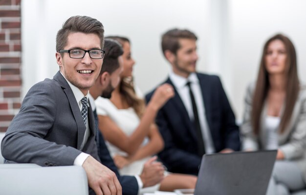 Uomo d'affari sorridente negli uomini d'affari sul posto di lavoro