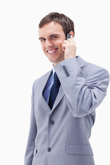 Uomo d&#39;affari sorridente sul cellulare