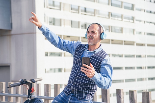 Uomo d'affari spensierato con le cuffie che ascolta felicemente la musica music