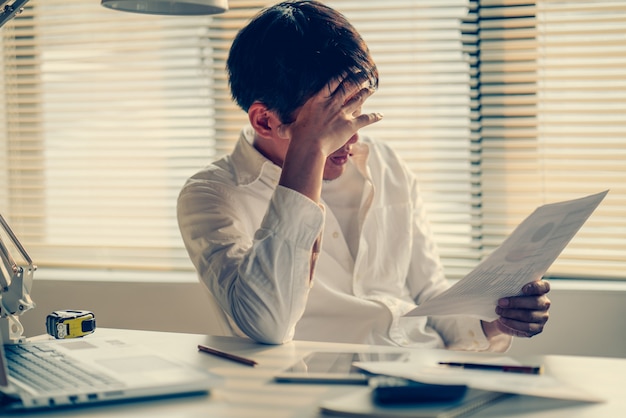 Uomo d'affari stressato e preoccupato per il ritardo per terminare il progetto di lavoro