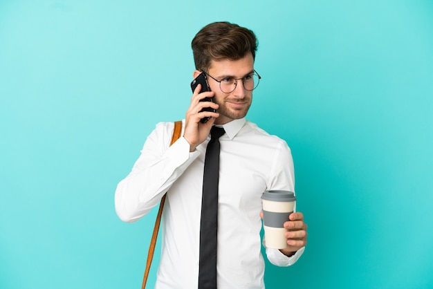 Uomo d'affari su sfondo isolato tenendo il caffè da portare via e un cellulare