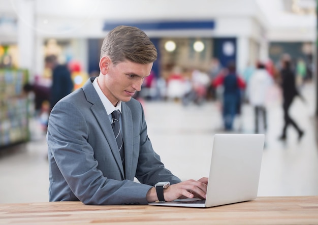 Uomo d'affari sul computer portatile nel centro commerciale