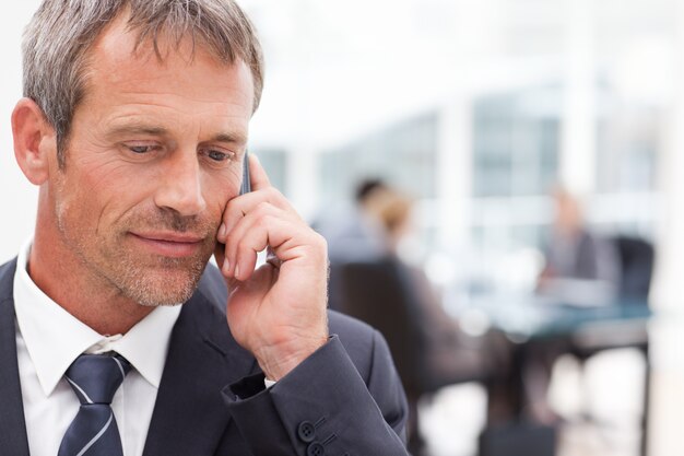 Uomo d&#39;affari telefonando nel suo ufficio