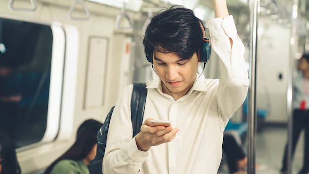 Uomo d'affari utilizzando il telefono cellulare sul treno pubblico