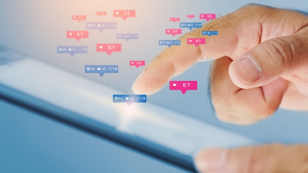 Uomo d'affari utilizzando la tavoletta digitale con icone sociali sullo schermo