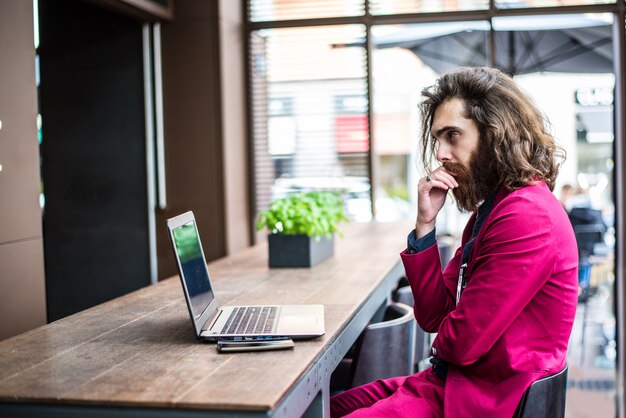 Uomo dei pantaloni a vita bassa che lavora al computer