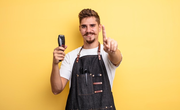 Uomo del barbiere hipster che sorride con orgoglio e sicurezza facendo il numero uno