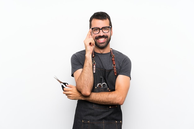 Uomo del barbiere in un grembiule con gli occhiali e felice