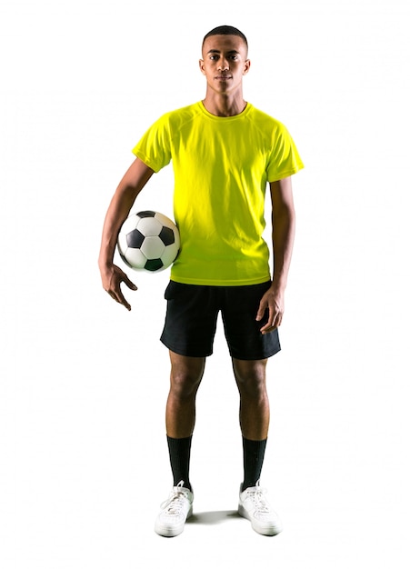 Uomo del calciatore con il gioco dalla pelle scura che prende una palla con le sue mani