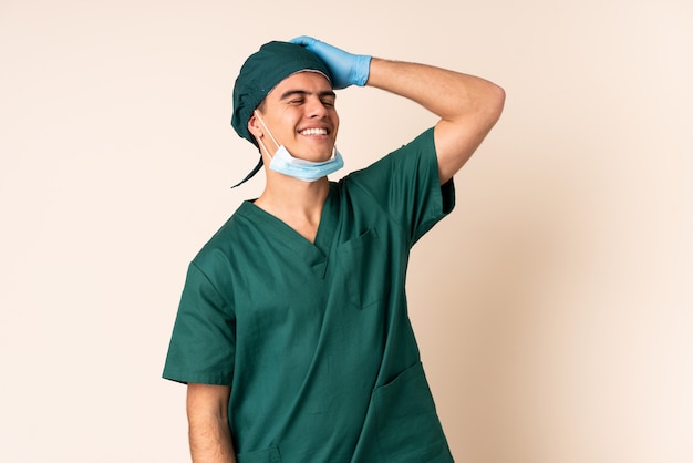 Uomo del chirurgo in uniforme blu sopra la risata isolata del fondo