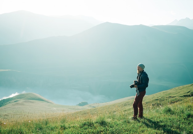 Uomo del fotografo che cammina in montagna.