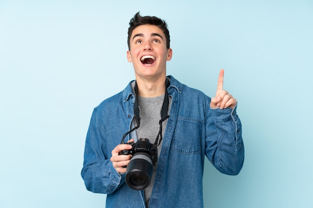 Uomo del fotografo dell'adolescente isolato sull'azzurro