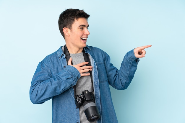 Uomo del fotografo dell'adolescente isolato sull'azzurro