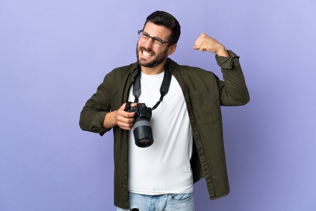 Uomo del fotografo sopra fondo viola isolato che fa forte gesto