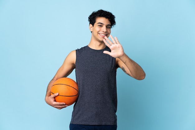 Uomo del giocatore di basket venezuelano oltre il conteggio di cinque con le dita