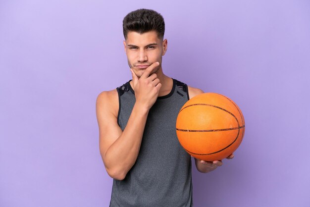 Uomo del giocatore di pallacanestro della giovane donna caucasica isolato sul pensiero viola del fondo