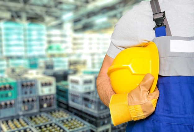 Uomo del lavoratore con il casco sullo sfondo