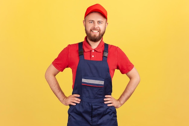 Uomo del lavoratore in piedi con le mani sui fianchi che guarda l'obbiettivo pronto a prendere e completare l'ordine