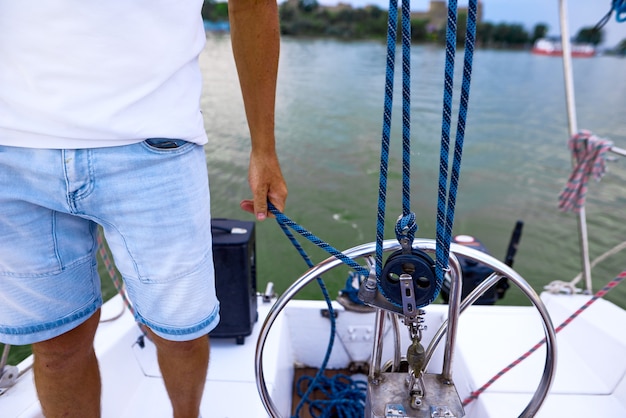 Uomo del marinaio in piedi accanto al volante dello yacht. profondità di campo foto.