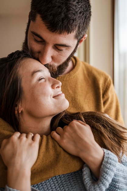 Uomo del primo piano che bacia donna sulla fronte