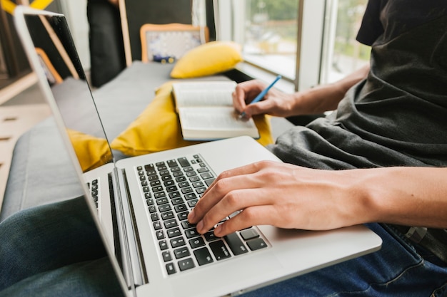 Uomo del primo piano che lavora al computer portatile