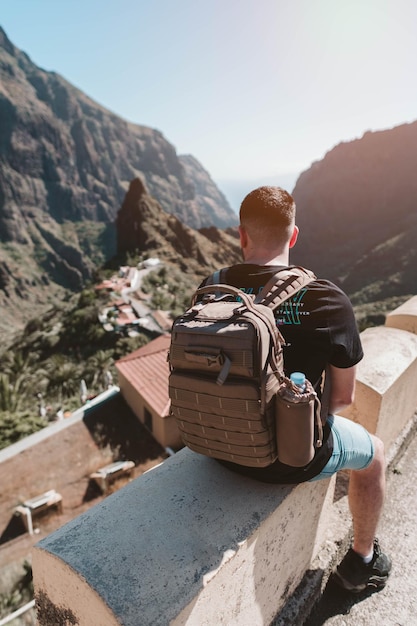 Uomo del viaggiatore con zaino e sacco a pelo che contempla il paesaggio a Tenerife