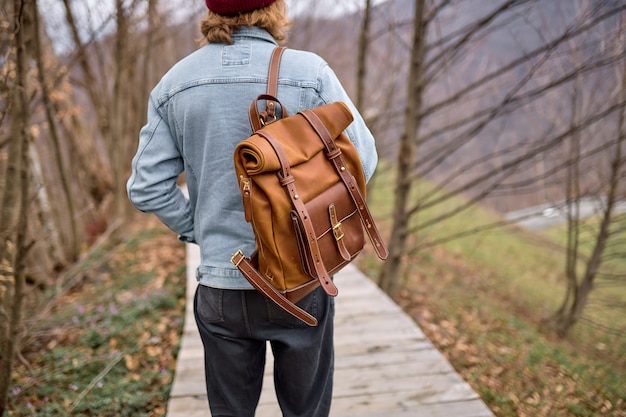 Uomo del viaggiatore di retrovisione che esplora i paesaggi della natura in primavera, camminando attraverso da solo