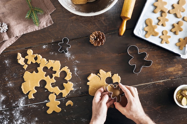 Uomo dell'alimento di Natale che cucina il dessert di natale di vista superiore dei biscotti del pan di zenzero