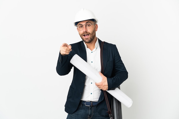 Uomo dell'architetto con il casco e che tiene le cianografie isolate su fronte sorpreso e puntato bianco