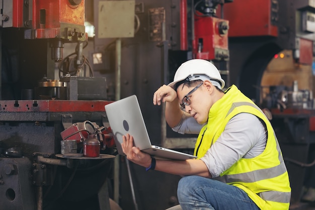 Uomo dell'ingegnere o tecnici che indossano mascherina chirurgica e utilizzando il computer portatile per il controllo