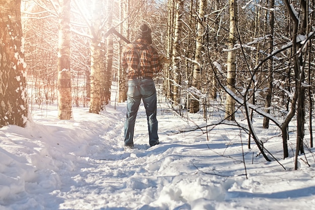 Uomo della foresta invernale di betulla con ascia