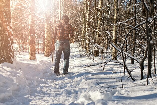 Uomo della foresta invernale di betulla con ascia