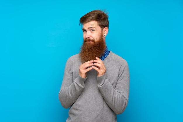 Uomo della testarossa con la barba lunga sopra lo schema blu isolato qualcosa