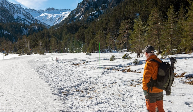 Uomo della viandante che cammina sulle montagne innevate dei Pirenei