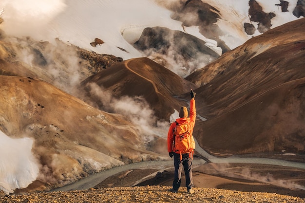 Uomo della viandante che sta a Kerlingarfjoll con la montagna del vulcano di estate alle Highlands dell'Islanda