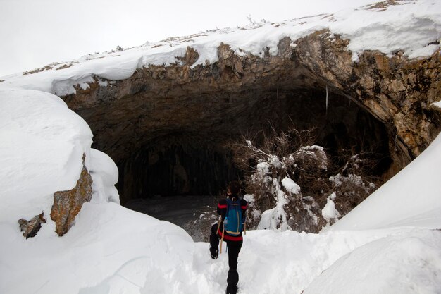 Uomo dello scalatore che cammina nella neve