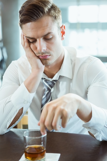 Uomo depresso, guardando il bicchiere di alcol