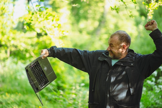 Uomo di 43 anni nella foresta con un computer portatile