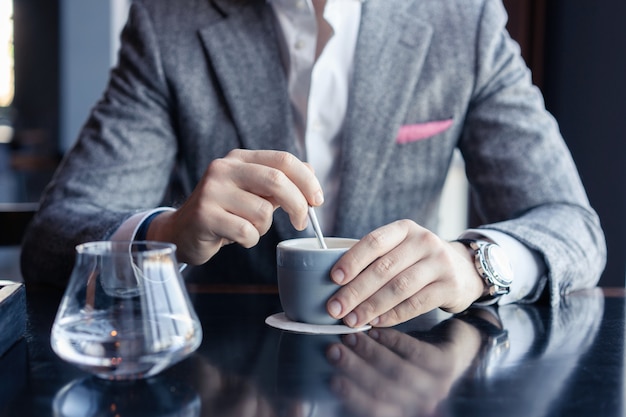 Uomo di affari che beve caffè in un caffè.