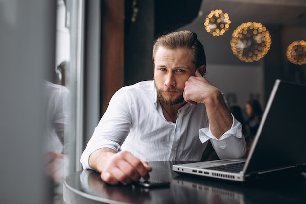 Uomo di affari che lavora al computer in un caffè