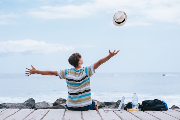 Uomo di affari che lavora sulla spiaggia con un computer portatile