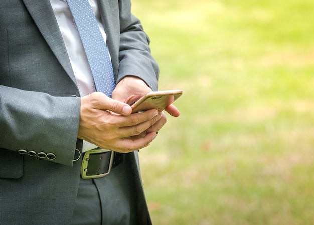 Uomo di affari che utilizza il telefono cellulare per trovare i dati per il suo lavoro