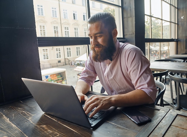 Uomo di buon umore che lavora con il computer