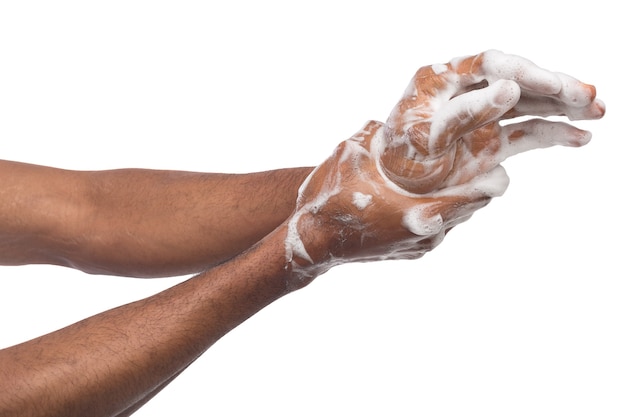 Uomo di colore lavarsi le mani con sapone isolato su sfondo bianco. Igiene, concetto di pulizia
